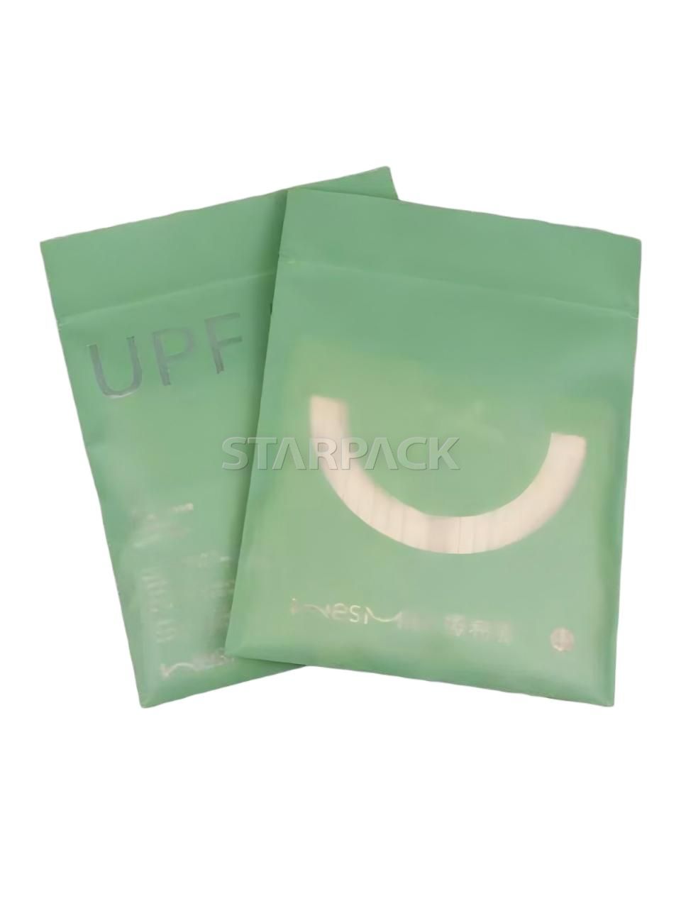 Two stacked matte green resealable bone bags with custom printed smile logo for food storage packaging