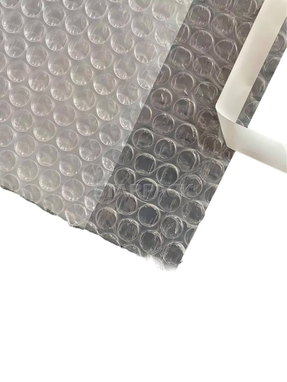 Angled folded detail shot clear plastic bubble courier bag, see-through shock absorbent packaging with strong self seal strip, customizable print transparent padded mailer for e-commerce retail